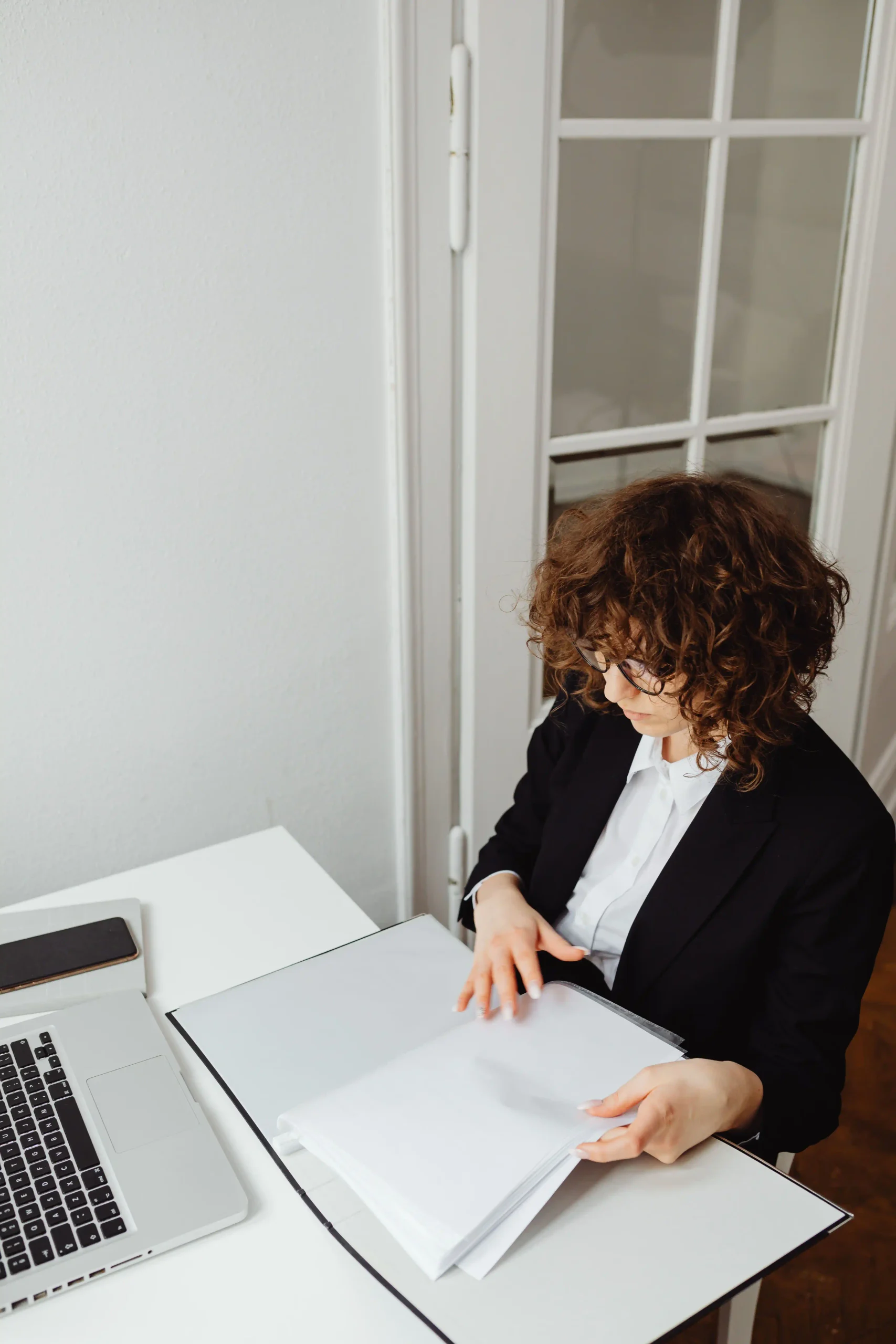 Femme professionnelle examinant des documents à son bureau